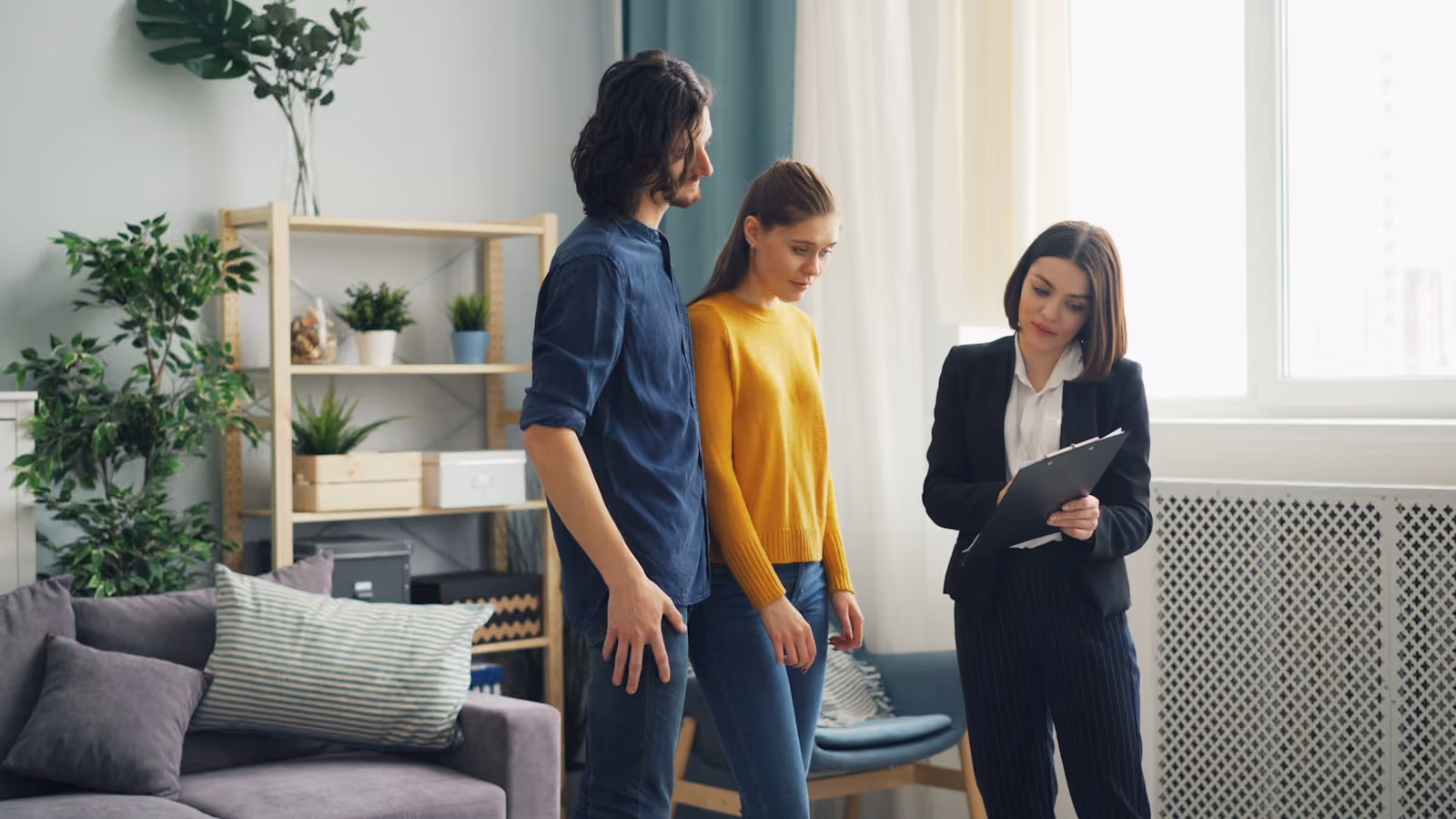 Ein Paar steht im Wohnzimmer der Immobilie, die es verkaufen will