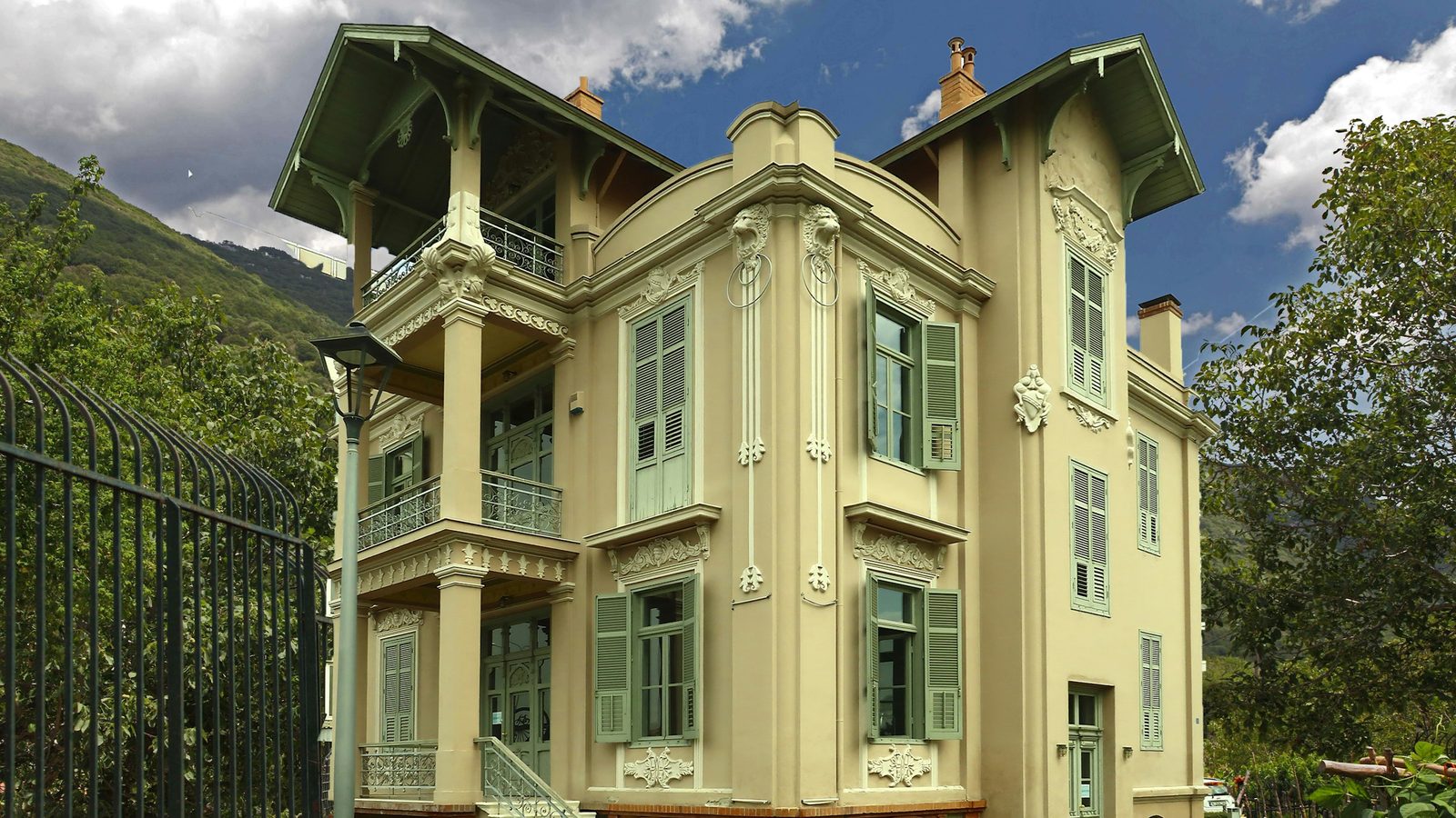 Historische Villa mit grünen Fensterläden und verzierter Fassade