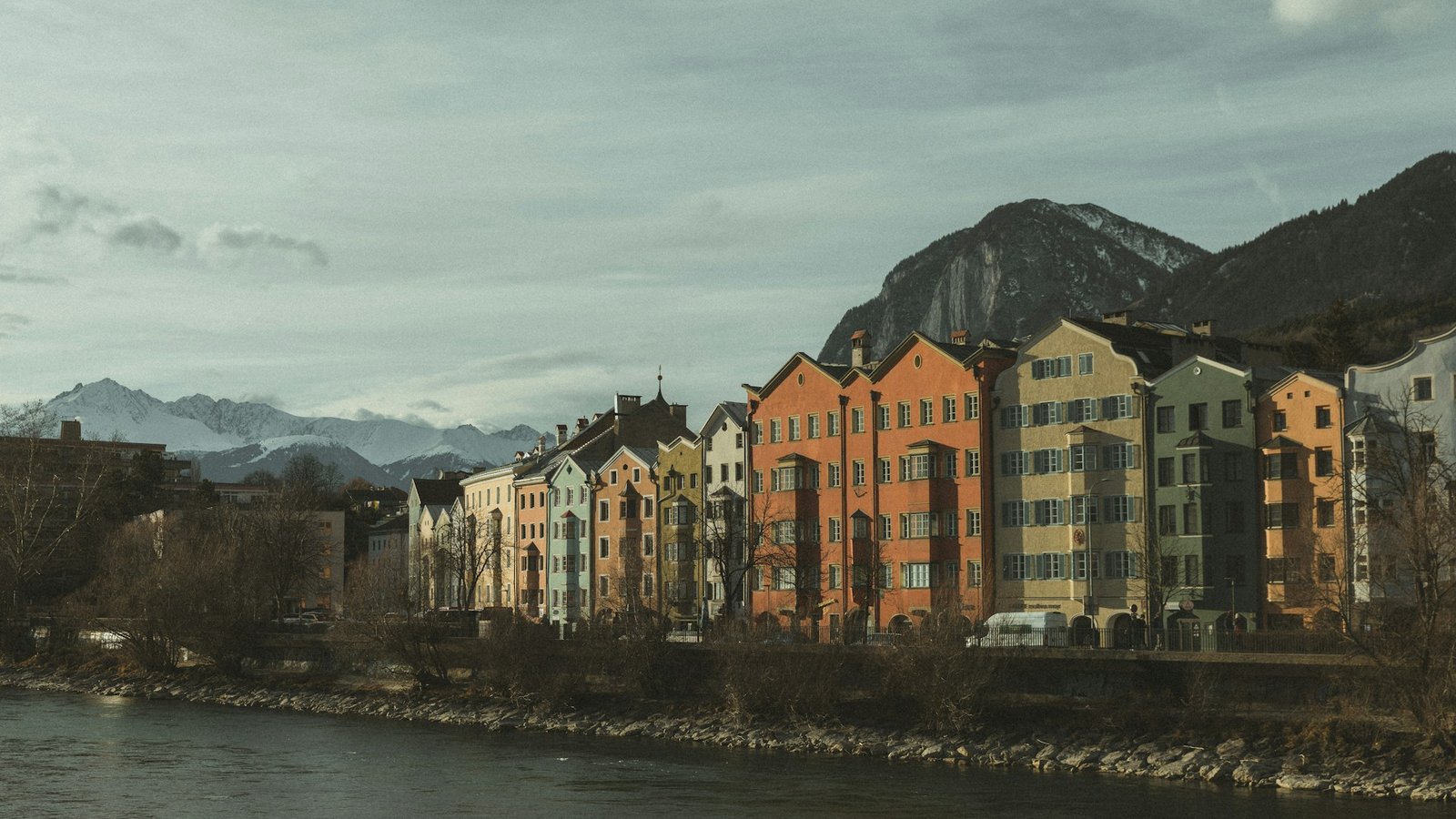 Wohnhäuser am Flussufer vor Bergen